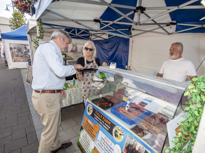 The Mayor of Causeway Coast and Glens Borough Council Councillor Richard Holmes enjoy a taste of the produce on offer from the Tully Farm stall at Causeway Speciality Market in Coleraine.