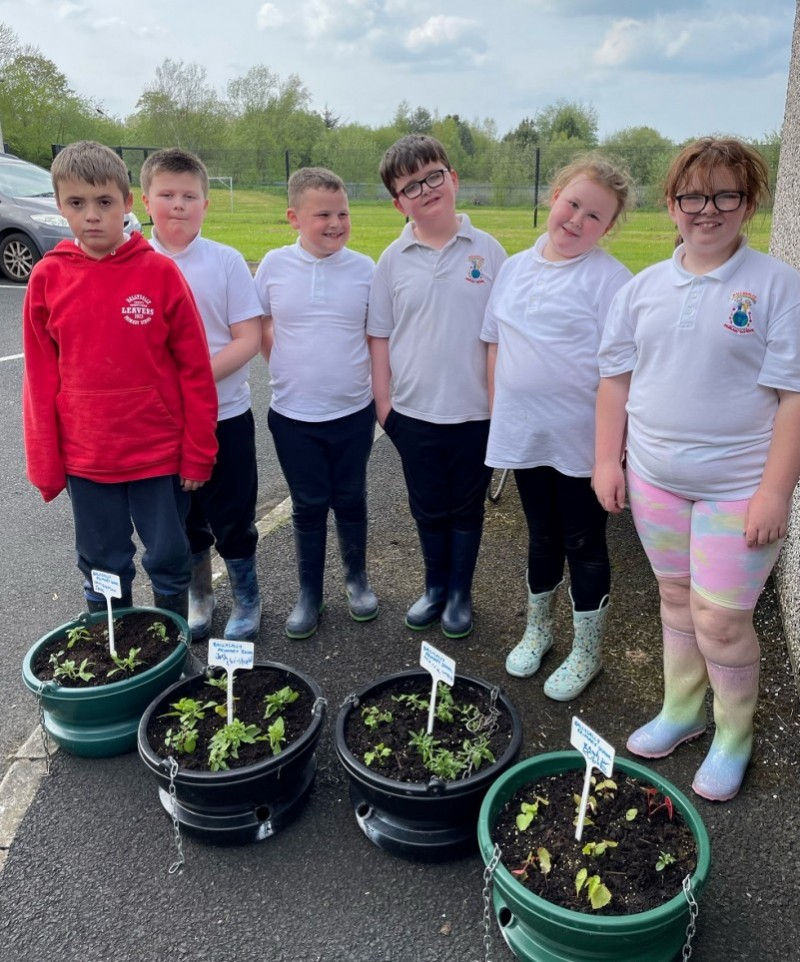 Children from Ballysally Primary School proudly showing the hanging baskets they made up for Coleraine’s town centre.