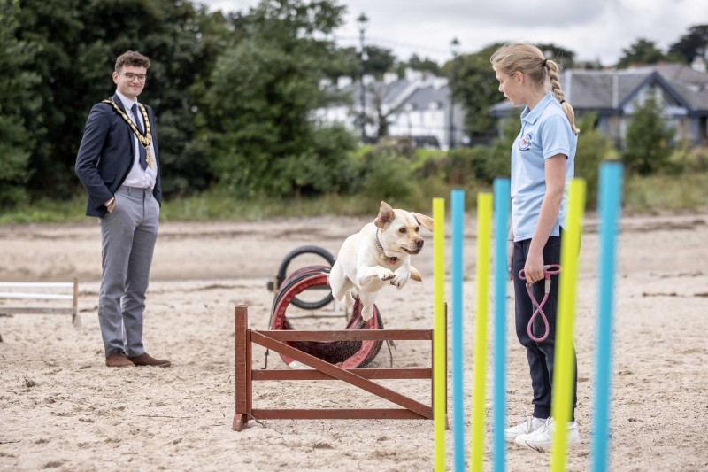 Mayor of Causeway Coast and Glens, Councillor Ciarán McQuillan watching a dog agility demonstration on Ballycastle beach on Saturday 24th August afternoon. The dog trainer from Ravara Dog Agility & Obedience Club, expertly guiding the dog across the obstacle course on the sand.