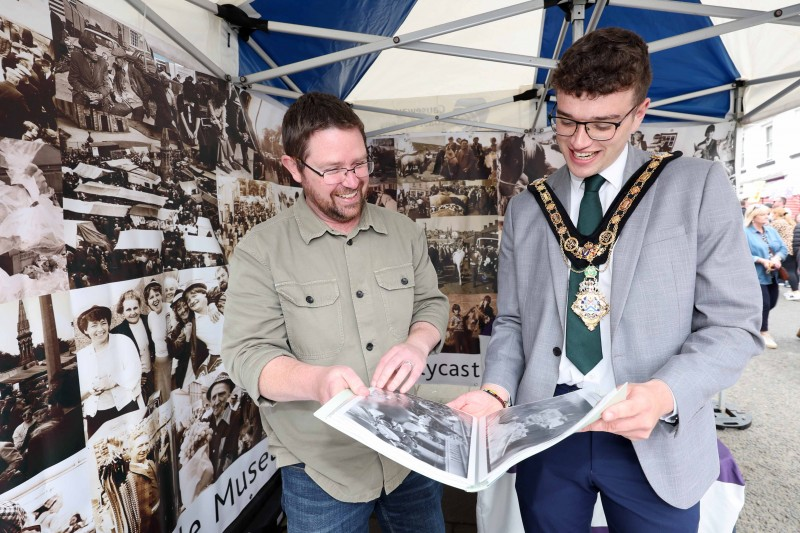 Causeway Coast and Glens Mayor Councillor Ciarán McQuillan pictured with Dr. Nic Wright, Ballycastle Project Officer, looking at photos of the Fair from times gone by at the Causeway Coast and Glens Museum Services tent outside Ballycastle Museum on Castle Street.