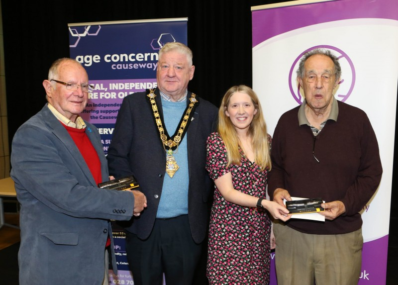 Mayor of Causeway Coast and Glens, Councillor Steven Callaghan and Museum Officer Jamie Austin presenting a gift to Tommy McDonald and Nelson McGonagle.