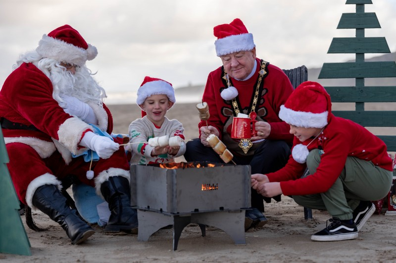 Daisy, Charlie and Hannah, Primary 4 pupils at Dunseverick Primary School, pictured with Santa Claus at Ballintoy Harbour as he prepares to take part in Causeway Coast and Glens Borough Council’s upcoming Christmas lights switch-on events in towns and villages across the area.