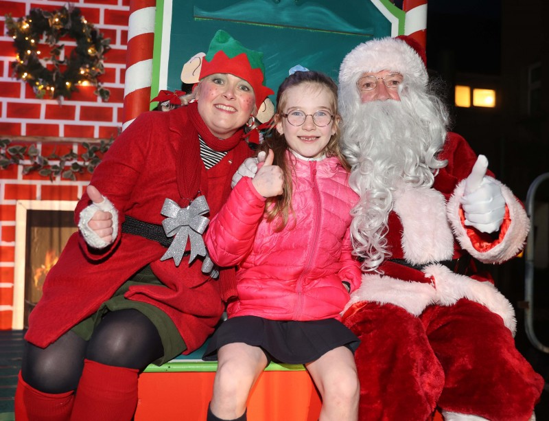 An excited child meeting Santa and his Chief Elf at the Christmas Light Switch On event in Ballycastle.