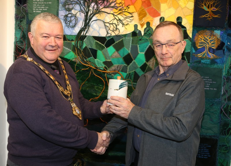 The Mayor of Causeway Coast and Glens Borough Council, Councillor Ivor Wallace, presents John Williams, the overall winner of the Dustbowl photography competition, with his prize, a piece of pottery made by Adam Frew.