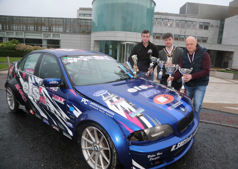 16-year-old Harry Kerr from Ballymoney displays some of his silverware with the Mayor of Causeway Coast and Glens Borough Council Councillor Sean Bateson and his father, Alwyn Kerr.