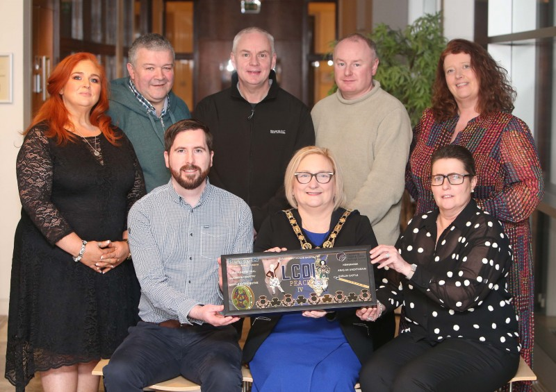 Pictured at the celebration event area Ashleen Schenning (LCDI), Ivor Wallace (Ullans Centre), Councillor Dermott Nicholl, Codie Murray (Ullans Centre), Joanne Kinnear (CEO LCDI), (front, seated) Johnny Mc Shane (Peace IV LCDI), the Mayor of Causeway Coast and Glens Borough Council Councillor Brenda Chivers and Louise Morrow (Ullans Centre)