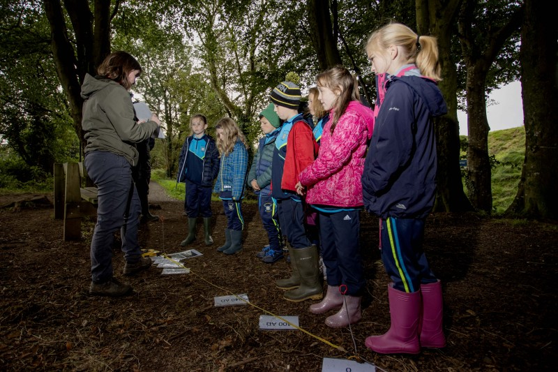 Pupils from St Peter’s and St Paul’s Primary School Foreglen, exploring the history of the Mountsandel site with Grace McAllister of the Causeway Coast and Glens Heritage Trust.