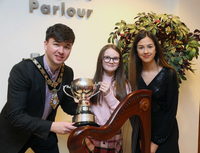 The Mayor of Causeway Coast and Glens Borough Council Councillor Sean Bateson pictured with young musicians Niamh Mooney and Sinéad Ní Cluasaigh.