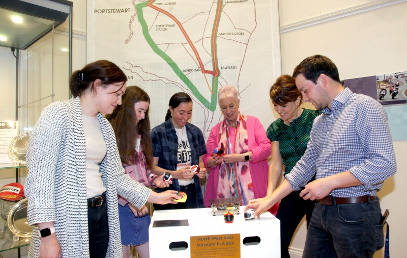 Rachel Archibald & Joanne Honeyford (Museums Officers) with participants and facilitators admiring their 3D printed helmets made during the Reimagine, Remake, Replay programme in Ballymoney Museum.