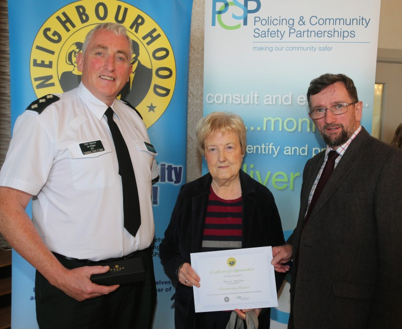 Yvonne Hamilton pictured receiving her award for over ten years’ service as a Neighbourhood Watch co-ordinator with Chief Inspector Ian Magee and PCSP Chairperson Alderman George Duddy.