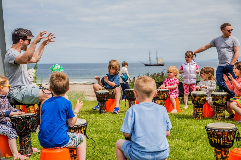 Children enjoying learning drums at the festival.