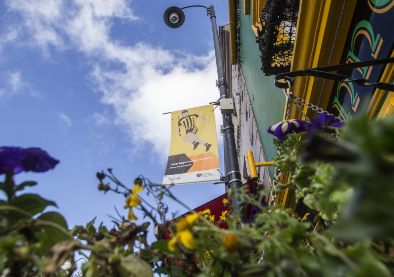 One of the banners currently on display on Ann Street in Ballycastle, featuring a hurler in the black and amber colours of MacQuillan’s GAA Club by Connor Donnelly.