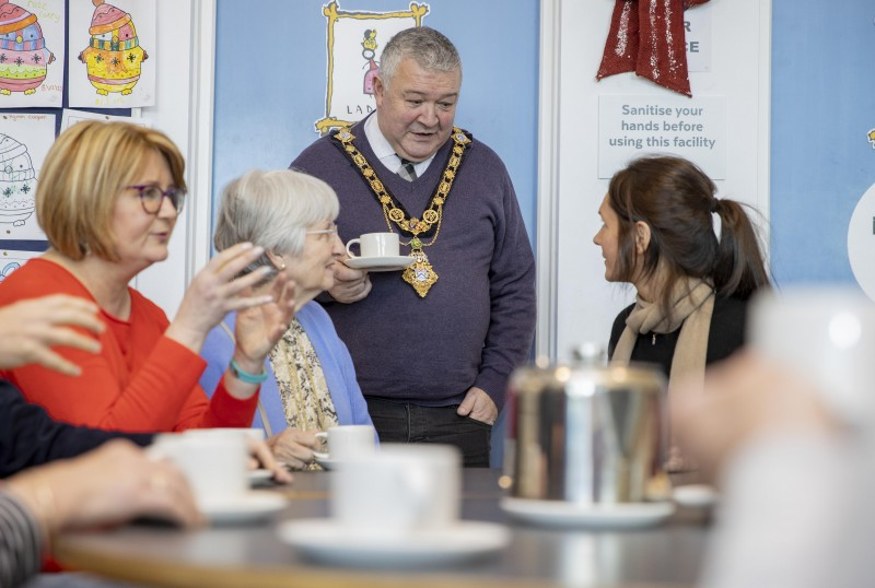 The Mayor of Causeway Coast and Glens Borough Council, Councillor Ivor Wallace, enjoys a cup of tea with an art class at Flowerfield Arts Centre in Portstewart, one of the Warm Welcome Spaces included in the new directory.