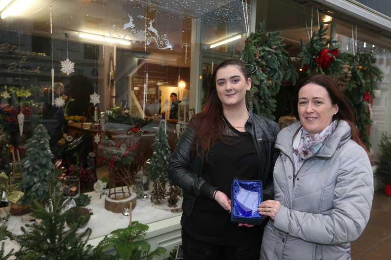 Shannon Ormandy from Blossom & Birch receive her prize from Causeway Coast and Glens Borough Council Officer Catrina McNeill for coming third in the Christmas Window Competition.