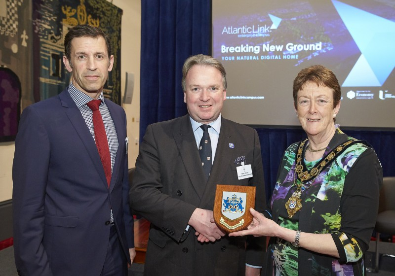 The Mayor of Causeway Coast and Glens Borough Council Councillor Joan Baird OBE presents a Coat of Arms to Henry Pollard of City of London Corporation alongside Causeway Coast and Glens Borough Council's Director of Leisure and Development Richard Baker.