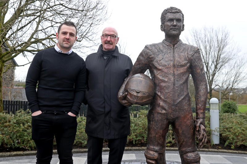 Michael Dunlop and Liam Beckett stand alongside the new statue of William Dunlop at the Dunlop Memorial Gardens in Ballymoney.