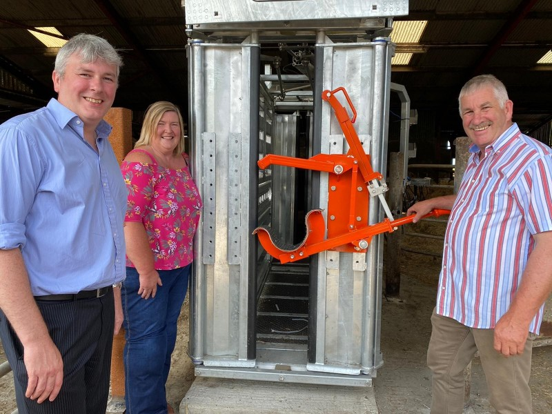 The Mayor of Causeway Coast and Glens Borough Council Councillor Richard Holmes pictured with Councillor Sandra Hunter, who runs her own farm near the Giant’s Causeway, and Victor Chestnutt, president of the UFU. This new crush was recently installed on the Chestnutt family farm outside Bushmills, which will make this type of work safer for everyone.