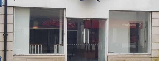 The vacant shop before it was transformed with images of Kitty of Coleraine and Hugh Thompson.