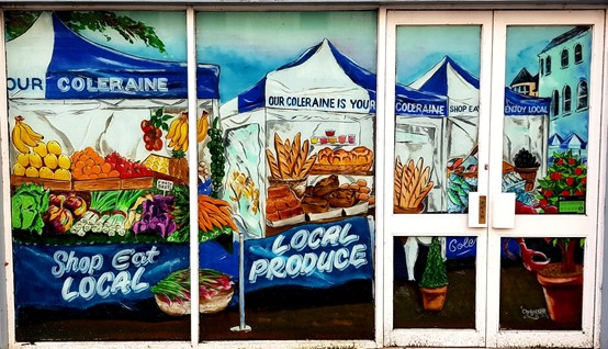 A vacant shop in Coleraine town centre has its windows transformed into this colour scene depicting Causeway Speciality Market.