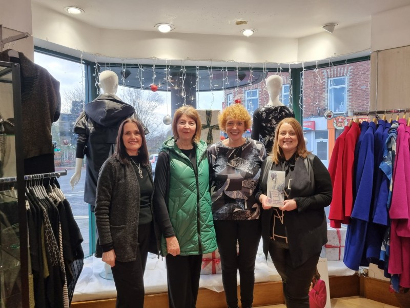 The ladies from the Winsome Lady in front of their festive window display